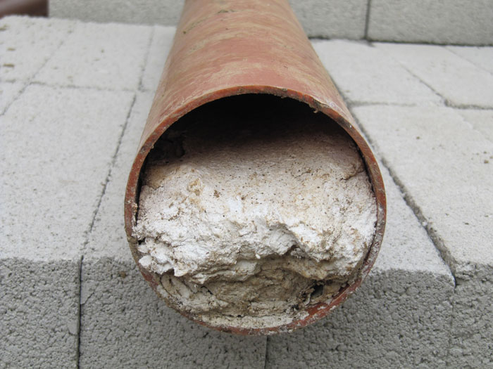 A section of clay pipe packed solid with fat