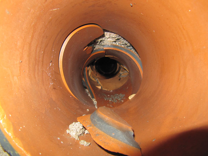 The camera view looking down the inside of an orange plastic drain pipe