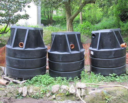 Three new black septic tanks waiting to go in on site