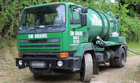 The green SW DRAINS tanker on a farm track